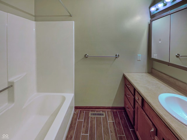 full bathroom with a tub, baseboards, wood finish floors, vanity, and a shower