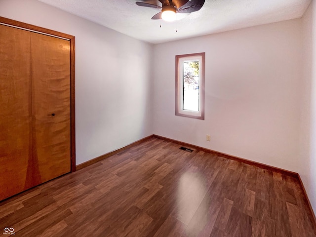 unfurnished bedroom with wood finished floors, visible vents, and baseboards