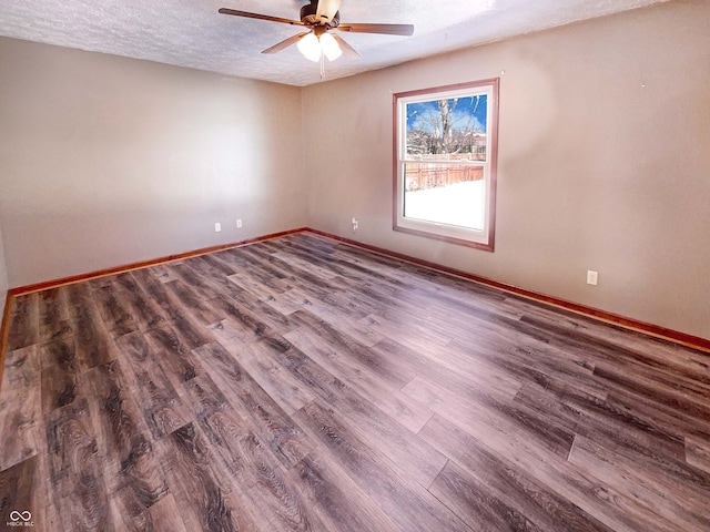 empty room featuring ceiling fan, wood finished floors, baseboards, and a textured ceiling