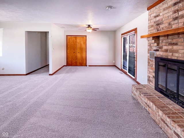 unfurnished living room with ceiling fan, baseboards, carpet flooring, a fireplace, and a textured ceiling