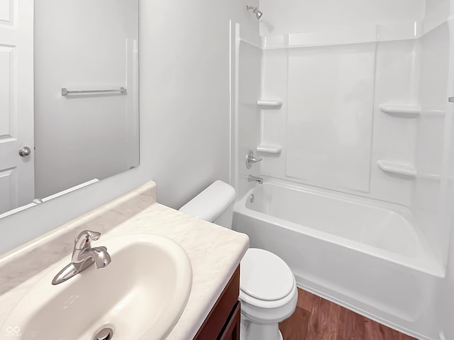 bathroom with shower / bathing tub combination, toilet, wood finished floors, and vanity