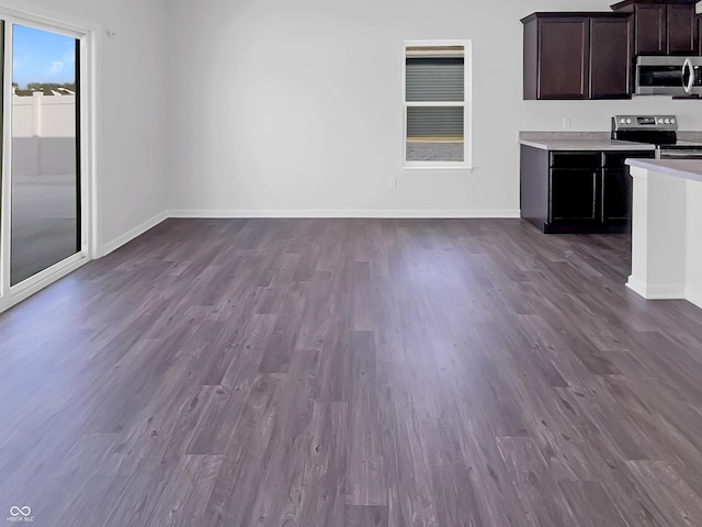 kitchen with light countertops, dark wood-style floors, baseboards, and stainless steel appliances