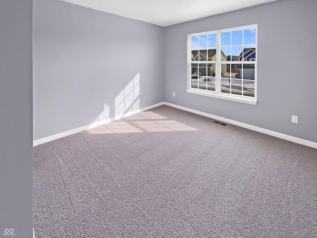 carpeted empty room featuring visible vents and baseboards