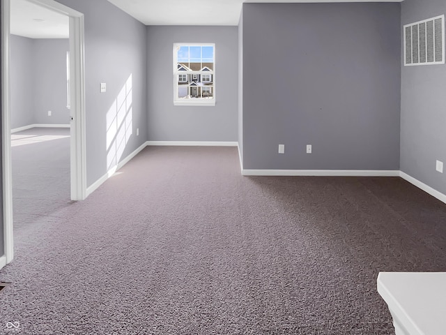 carpeted spare room with visible vents and baseboards