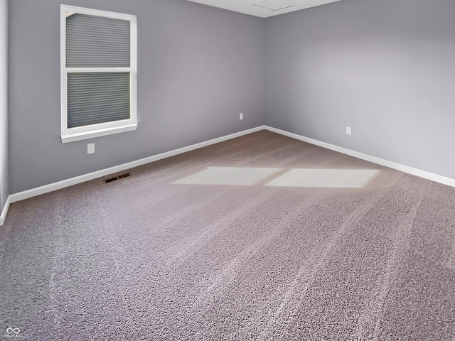 spare room featuring carpet, baseboards, and visible vents