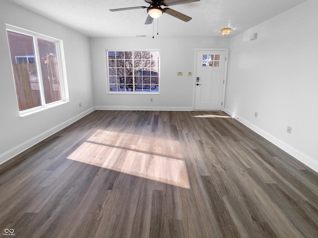 interior space featuring ceiling fan, a wealth of natural light, baseboards, and wood finished floors