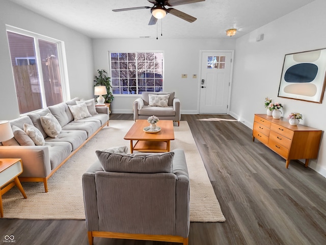 living room with a textured ceiling, a ceiling fan, dark wood-type flooring, and baseboards