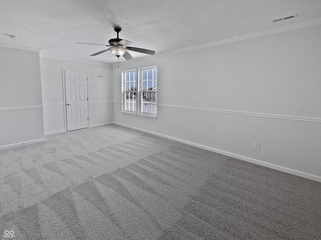 spare room with visible vents, ornamental molding, a textured ceiling, carpet floors, and baseboards