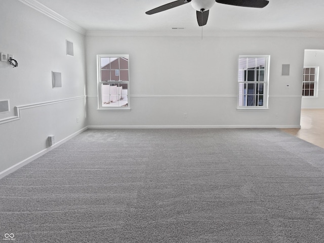 carpeted empty room featuring visible vents, ceiling fan, crown molding, and baseboards