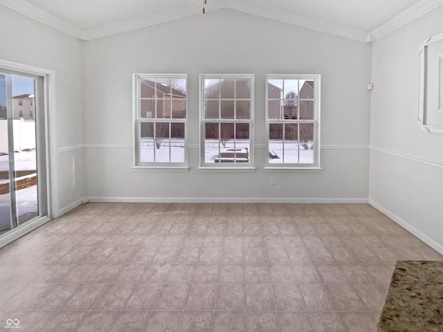 spare room featuring baseboards, crown molding, and vaulted ceiling