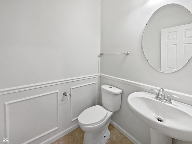 bathroom featuring a sink, toilet, and tile patterned floors