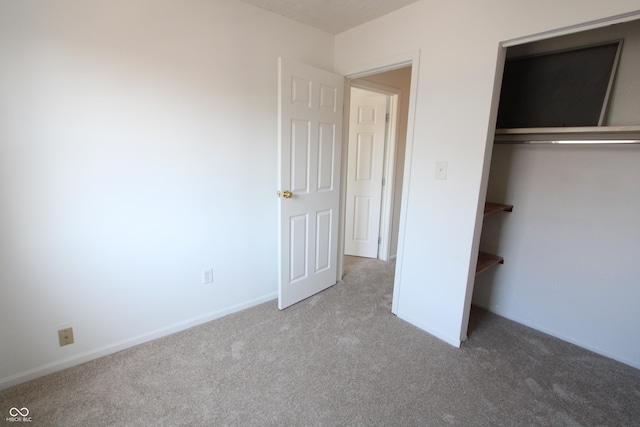 unfurnished bedroom featuring a closet, baseboards, and carpet