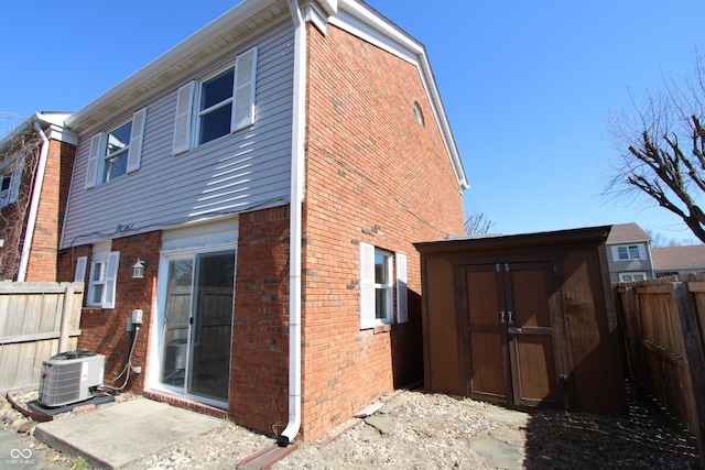 back of property with brick siding, a shed, and a fenced backyard