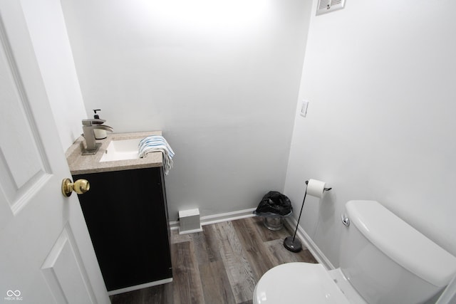 bathroom featuring visible vents, toilet, vanity, and wood finished floors