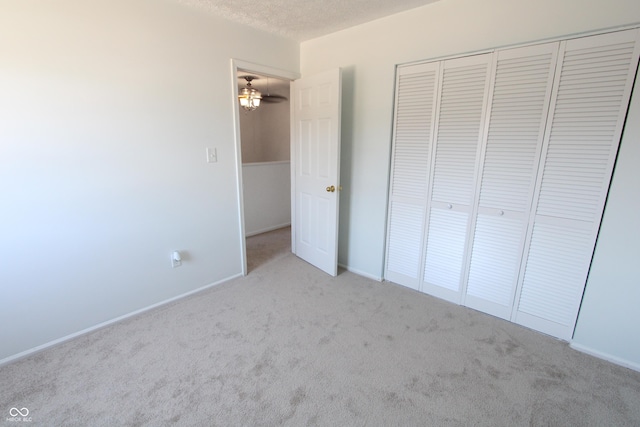 unfurnished bedroom with carpet, a closet, and a textured ceiling