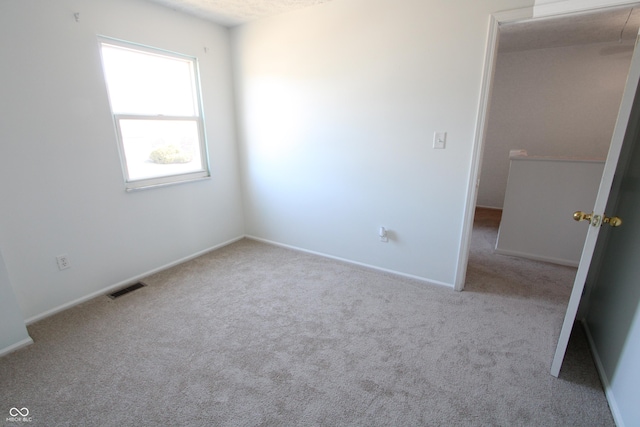 unfurnished room featuring visible vents, baseboards, and carpet floors