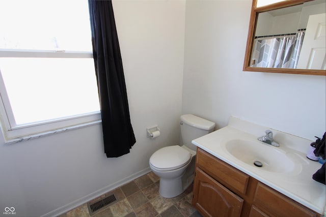 full bathroom with visible vents, toilet, curtained shower, baseboards, and vanity