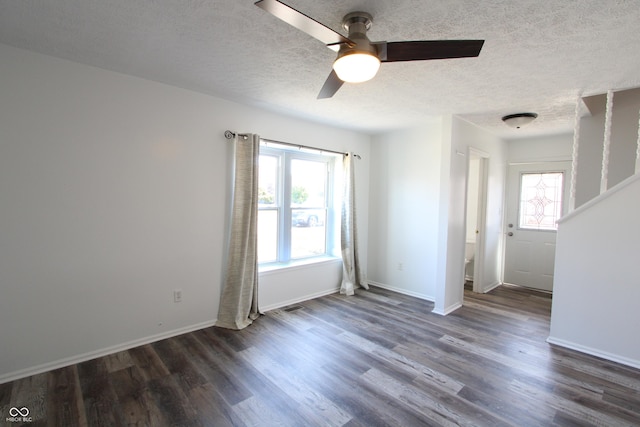 unfurnished room with dark wood finished floors, a ceiling fan, baseboards, and a textured ceiling