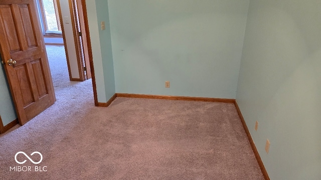 carpeted empty room with baseboards