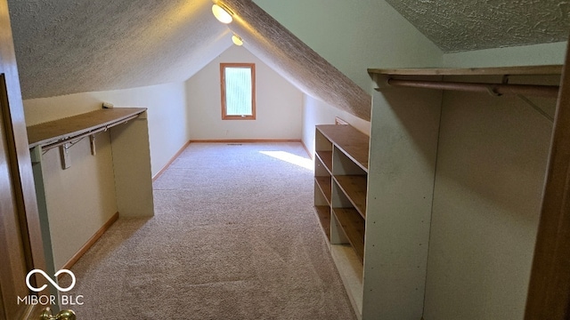 bonus room featuring baseboards, light carpet, a textured ceiling, and vaulted ceiling