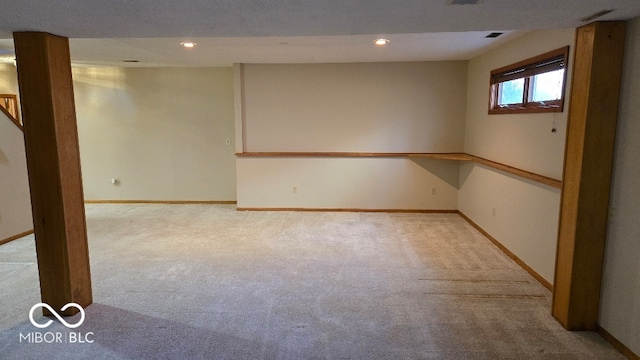 below grade area featuring recessed lighting, baseboards, and light carpet