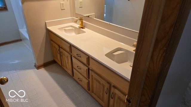 bathroom featuring double vanity, a tub, baseboards, and a sink