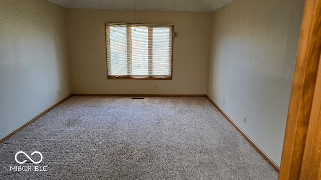 spare room with visible vents, baseboards, and carpet flooring