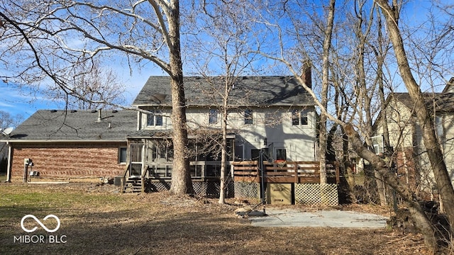 back of property featuring a wooden deck, a shingled roof, and a sunroom