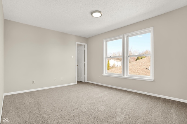 carpeted empty room featuring baseboards and a textured ceiling