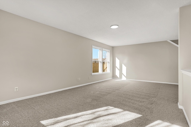 carpeted spare room featuring baseboards