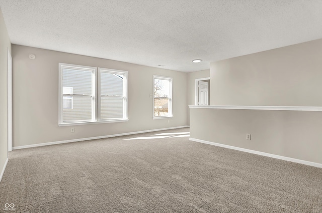 unfurnished room with baseboards, carpet floors, and a textured ceiling