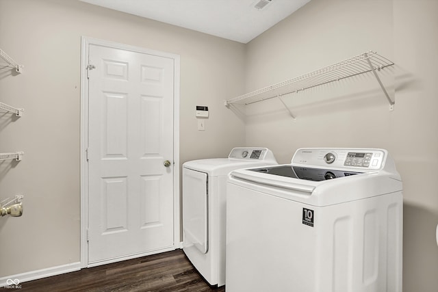 laundry area with visible vents, dark wood-type flooring, baseboards, washer and clothes dryer, and laundry area