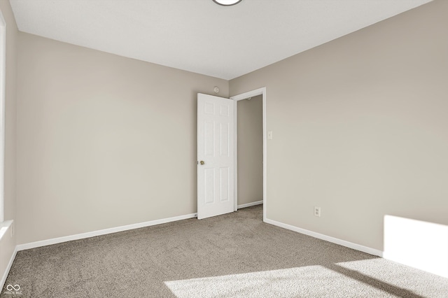 carpeted empty room with baseboards