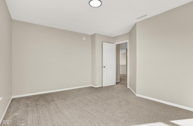 spare room featuring baseboards and carpet floors