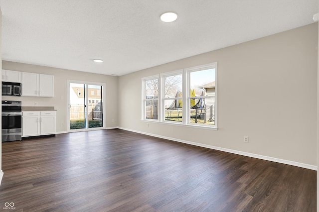 unfurnished living room with dark wood finished floors and baseboards