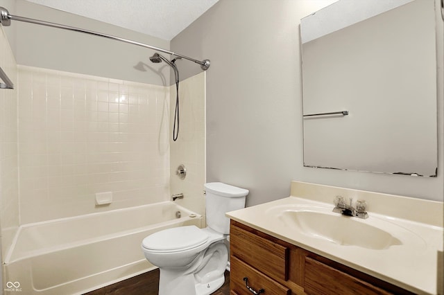 full bathroom featuring toilet, vanity, bathing tub / shower combination, wood finished floors, and a textured ceiling