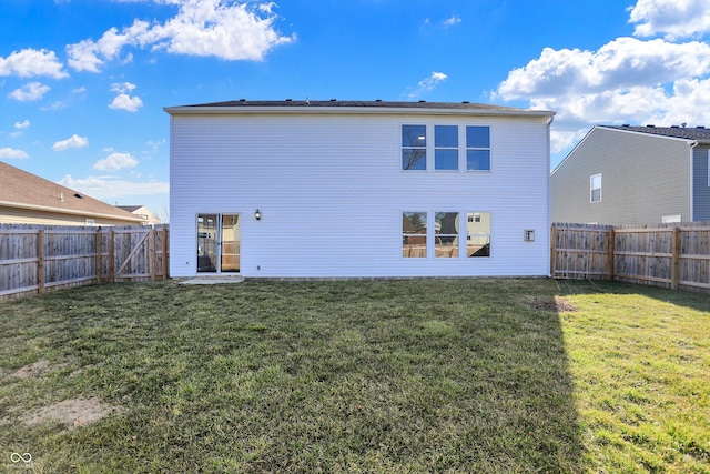 back of house with a lawn and a fenced backyard