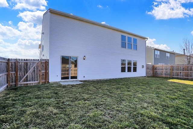 rear view of property with a yard and a fenced backyard