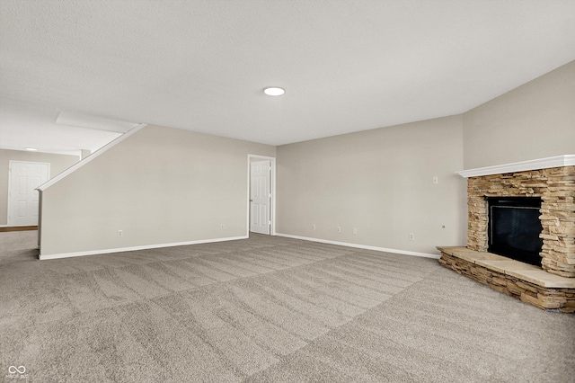 unfurnished living room featuring stairs, carpet flooring, a fireplace, and baseboards