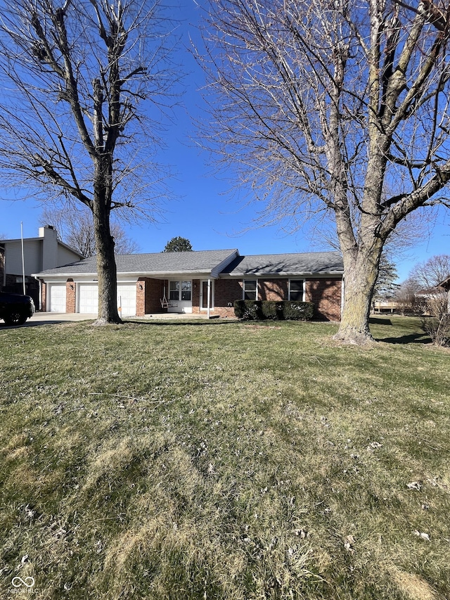 ranch-style house with brick siding, a front lawn, and a garage