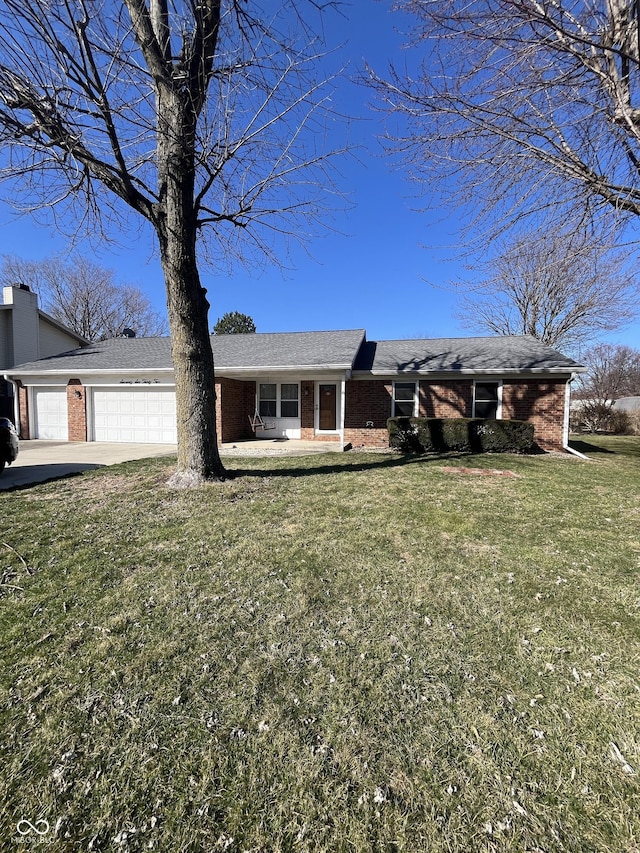 view of front facade featuring driveway, brick siding, an attached garage, and a front lawn