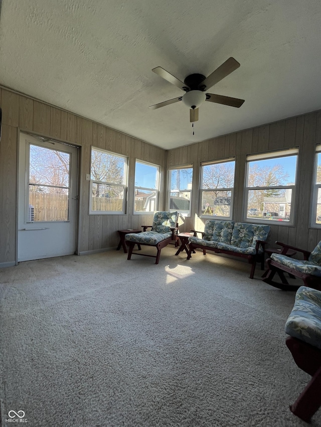 sunroom / solarium featuring plenty of natural light and a ceiling fan