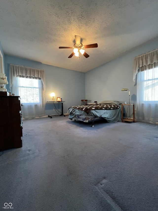 unfurnished bedroom with baseboards, carpet flooring, a textured ceiling, and a ceiling fan