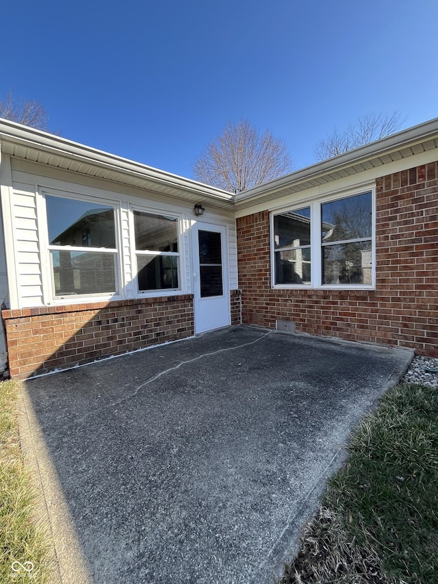 view of exterior entry featuring brick siding