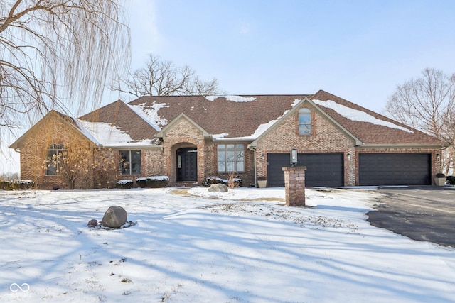 view of front facade featuring brick siding, driveway, and a garage