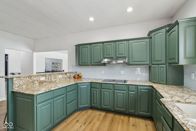 kitchen with black electric cooktop, under cabinet range hood, and green cabinetry