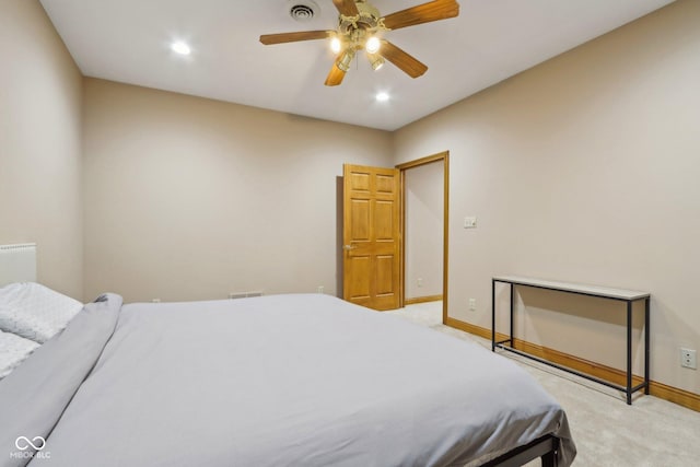 bedroom with a ceiling fan, light colored carpet, visible vents, and baseboards