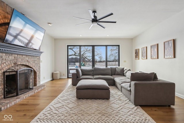 living room with recessed lighting, baseboards, wood finished floors, and a fireplace