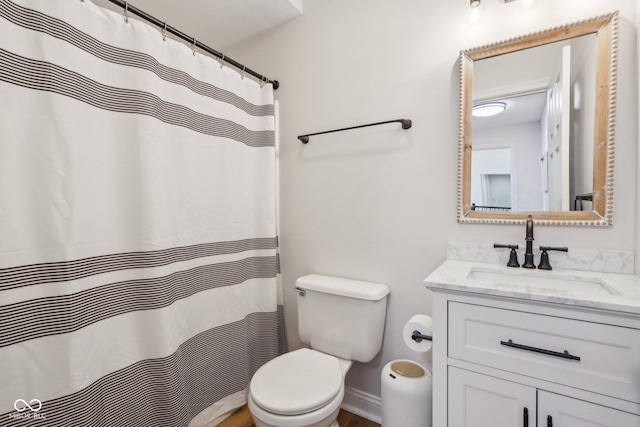 full bath with baseboards, toilet, and vanity