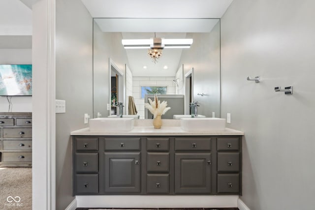 bathroom featuring a sink, baseboards, and double vanity